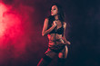 Leinwandbild Motiv Portrait of lovely magnificent stunning gorgeous charming adorable attractive sporty wavy-haired lady wearing tightening swordbelt teasing isolated over black red light background