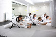 © didesign - Experienced martial art fighters and one physically disabled young girl stretching together