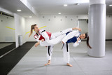 Two girls celebrating sports and demonstrating martial art of taekwondo