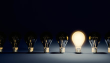 Row Of Switched Off Light Bulbs With One Lit On And Shining. Idea, Leadership Or Creativity Concepts. 3d Rendering Illustration With Copy Space.