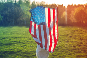 Happy women patriot running in the field with American flag. USA celebrate 4th of July