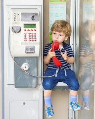  Emotional boy talking on the phone. A conversation on the landline. Emotions. The voice of the red handsets. 