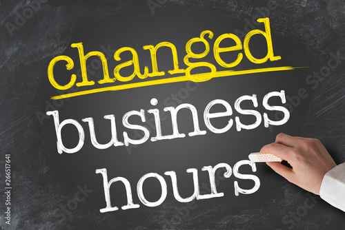 Cuadros en Lienzo text CHANGED BUSINESS HOURS written on blackboard with hand holding piece of cha