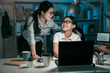 © PR Image Factory - team work partner working with laptop computer late at night office smiling looking chatting. ceo with asian female intern girl having conversation after deal with project on deadline in midnight.