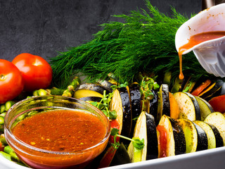 Ratatouille - traditional French Provencal vegetable dish cooked in oven pouring with tomato, olive oil sauce