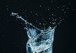 © MACO - Water splash in glass with black background