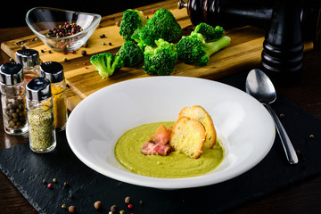 Wall Mural - Broccoli cream soup with bread on a table. Classic European food