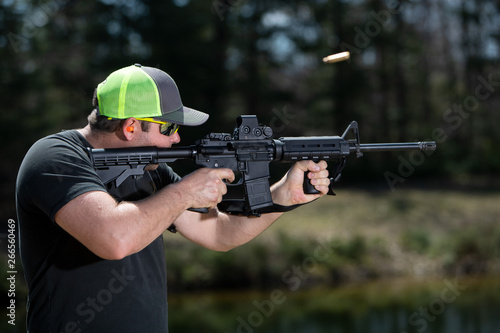 Fotomural Close-up of man shooting a rifle with the ejected shell.