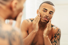 African American Man Applying Cosmetic Scrub Cream On His Face