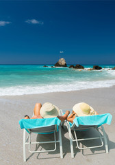 Couple on sunbeds relaxing at the beach in Lefkada