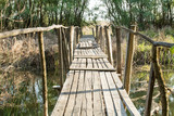 Fototapeta Dziecięca - old dilapidated wooden plank bridge across river