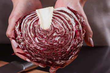 young woman in a gray aprons cuts radicchio