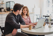 © sashafolly - Two young people working with a laptop in a cafe and drinking coffee
