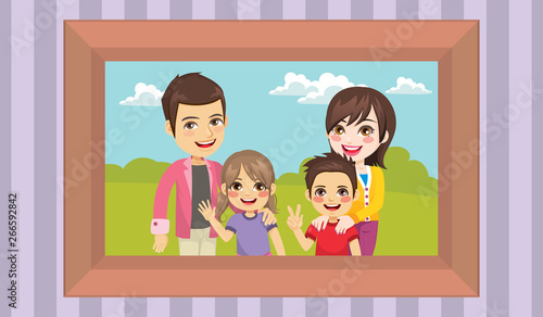 Family portrait in a frame on the wall mom dad and children happy posing toge...