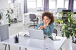 © nenadaksic - Cute mixed race businesswoman dressed  casual thinking how to solve a problem while sitting in modern office.