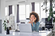 © nenadaksic - Cute mixed race businesswoman dressed  casual thinking how to solve a problem while sitting in modern office.