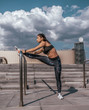 © byswat - Girl athlete in tattoos, in the summer in city, trains fitness, gymnastics workout. Sportswear leggings top. In the morning before the run. Background steps, sky clouds.