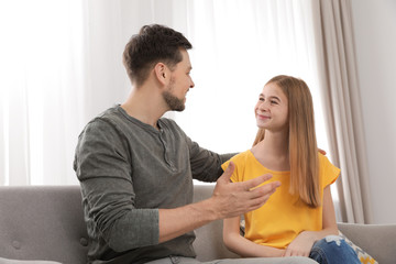 Wall Mural - Father talking with his teenager daughter at home