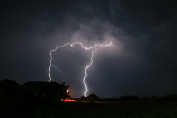 Wall Mural - dramatic lightning over a house in romania, causing a spooky atmosphere