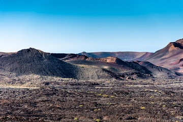 Wall Mural - Timanfaya National Park martian landscape, Lanzarote, Canary Islands, Spain. Unique panoramic view of spectacular lava river flows from huge volcano craters.