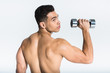 © LIGHTFIELD STUDIOS - handsome mixed race man with muscular torso holding dumbbell on white