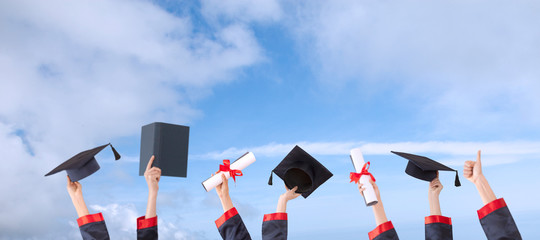 graduation ceremony concept hat and diploma up raised hands