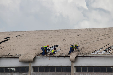 Aftermath Cyclone Idai and Cyclone Kenneth in Mozambique and Zimbabwe, people fixing damaged roof 