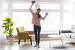 © fizkes - Cheerful woman makes house cleaning holding rag spray bottle detergent