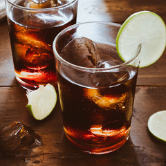 Cola lemon soda drink on wooden table bar with light back frome window. crop 1:1 ratio image.