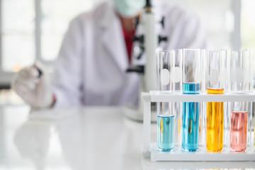 Wall Mural - a scientist hands working in laboratory with test tube microscope and solutions.