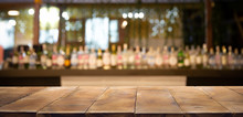 Defocused Background And Bottles Of Restaurant, Bar Or Cafeteria Background. Wooden Table Top For Product Display.