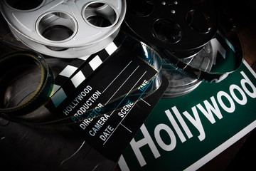multiple film reels and a clapboard on a wooden background. film, hollywood, entertainment industry 
