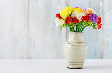 Poster - Bouquet of colorful freesia flowers in ceramic vase.