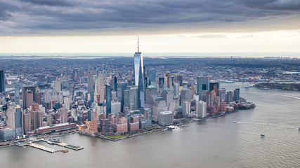 Canvas Print - New York City from helicopter point of view. Downtown Manhattan, Jersey City and Hudson River on a cloudy day