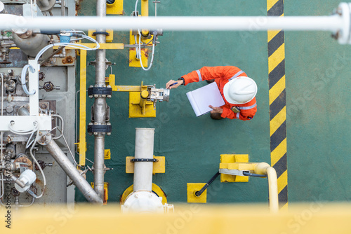 Fotografía Oil and gas industry activity, operator check and inspect oil pump differential gauge and pressure transmitter as daily log sheet record for monitor production process
