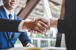 © Ngampol - Finishing up a meeting, handshake of two happy business people after contract agreement to become a partner, collaborative teamwork