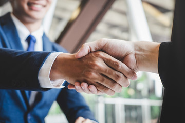 Finishing up a meeting, handshake of two happy business people after contract agreement to become a partner, collaborative teamwork