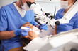 © gpointstudio - Dentist using dental microscope and examining woman's teeth