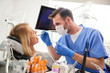 © gpointstudio - Focused dentist using dental drill and dental mirror