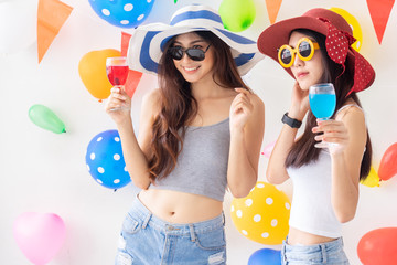 celebration new year or birthday party group of asian young woman and confetti happy,funny concept.drinking wine happy and fun in new year celebrate, color balloon  background.