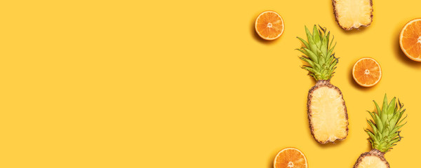 Wall Mural - Pineapples, oranges, lemons, coconuts on yellow background. Summer fruits. Flat lay, top view, copy space