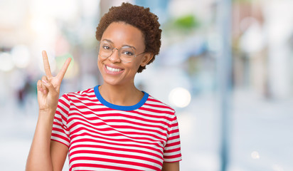 Beautiful young african american woman wearing glasses over isolated background showing and pointing up with fingers number two while smiling confident and happy.