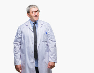 Wall Mural - Handsome senior doctor, scientist professional man wearing white coat over isolated background smiling looking side and staring away thinking.