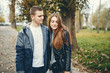 © hetmanstock2 - Cute couple walking in a autumn park. Boy in a black jacket. Girl in a gray dress