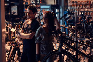 Wall Mural - Young master and his attractive apprentice are taking a break after repairing a bicycle at workshop.