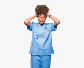 young african american doctor woman over isolated background crazy and scared with hands on head, af