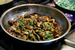 saute mushrooms in a cooking pan