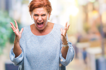 Sticker - Atrractive senior caucasian redhead woman wearing winter sweater over isolated background celebrating mad and crazy for success with arms raised and closed eyes screaming excited. Winner concept