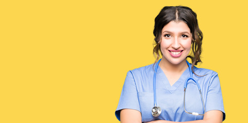 Young adult doctor woman wearing medical uniform happy face smiling with crossed arms looking at the camera. Positive person.