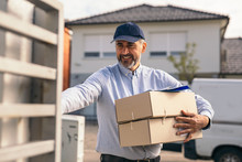 Delivery Man Holding Parcel Boxes And Ringing On The Door Bell